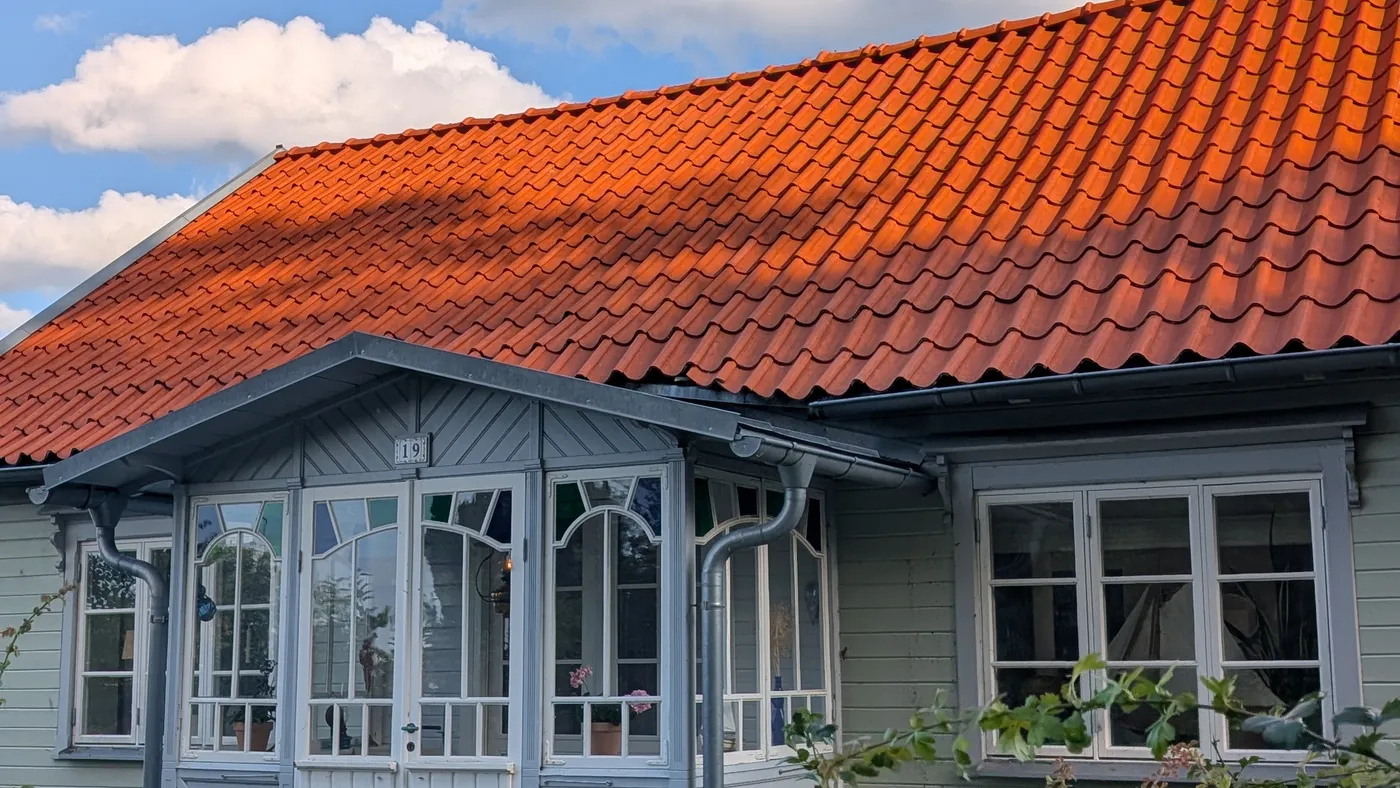 Villa med rent tegelrött tak och ljus fasad efter behandling